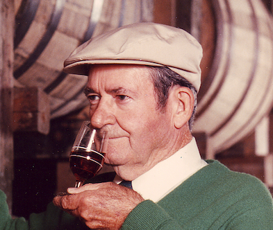 Elmer T. Lee sipping bourbon in a warehouse
