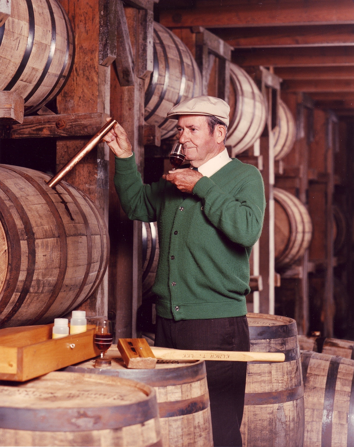 Elmer T. Lee sampling bourbon inside a warehouse